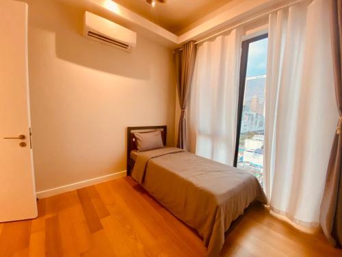 a bedroom with a bed and a large window at Sentral Suites Kuala lumpur By Leyla 3BR suites 8 pax in Kuala Lumpur