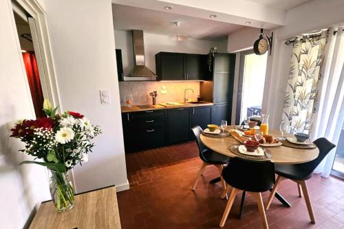 une cuisine et une salle à manger avec une table et des chaises dans l'établissement Cozy T2 with garden near the sea, à Saint-Mandrier-sur-Mer