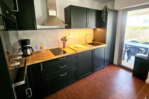 une cuisine avec des placards verts et un comptoir dans l'établissement Cozy T2 with garden near the sea, à Saint-Mandrier-sur-Mer