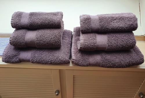 a pile of purple towels sitting on top of a table at Bi üüs Itüüs in Wenningstedt