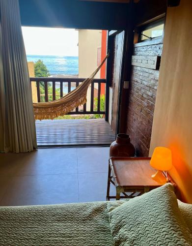 a bedroom with a bed and a view of the ocean at Pousada Bem Te Vi in Guarapari