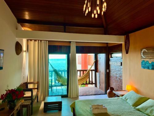 a bedroom with a bed and a sliding glass door at Pousada Bem Te Vi in Guarapari