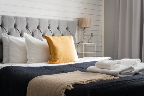 a bedroom with a large bed with a yellow pillow at Guestly Homes - Modern 4BR Villa with Sauna in Piteå