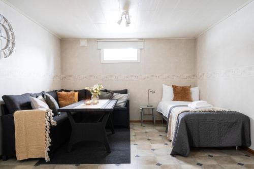 a living room with a couch and a bed at Guestly Homes - Modern 4BR Villa with Sauna in Piteå