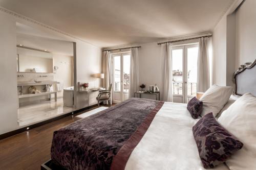 a bedroom with a large bed with a large window at Hospes Puerta de Alcalá, a Member of Design Hotels in Madrid