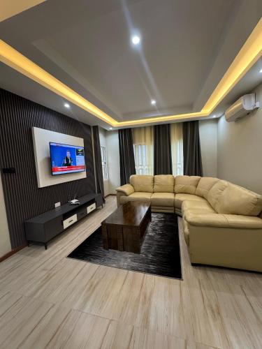 a living room with a couch and a flat screen tv at Meanwood Place Apartments in Lusaka