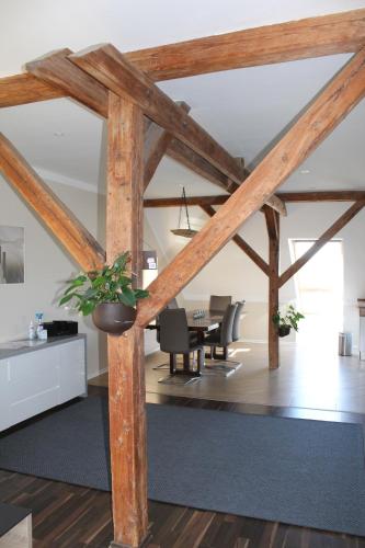 a living room with wooden beams and a dining room at Ferienwohnung "Turmblick" in Tellingstedt