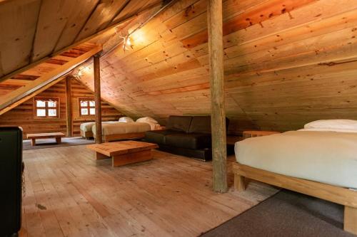 a bedroom in a log cabin with a bed and a couch at Torre de Carpio, Cabaña Molitor in San Isidro