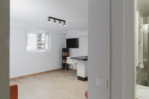 a white living room with a desk and a television at Residence i Tigli in Cinisello Balsamo
