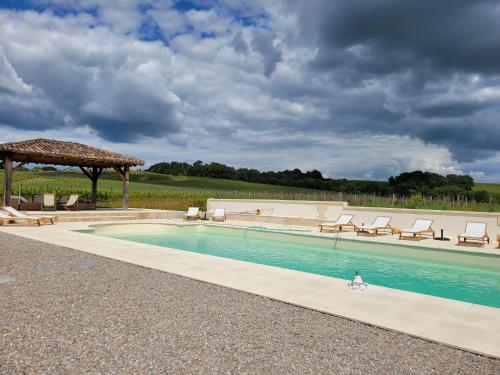 une piscine avec des chaises et un gazebo dans l'établissement CHATEAU de POTIRON, à Capian