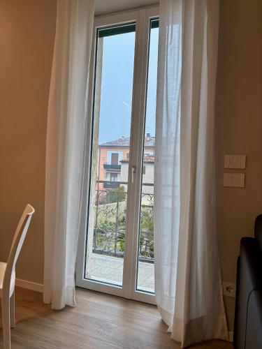 a room with a large window with white curtains at Palazzo Betteloni in Bardolino