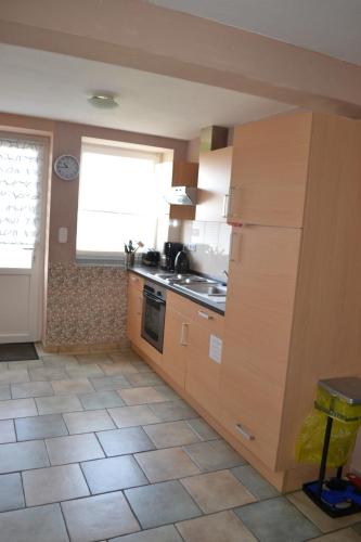 a kitchen with a sink and a stove and a window at Wohnung "Amsterdam" in Heede