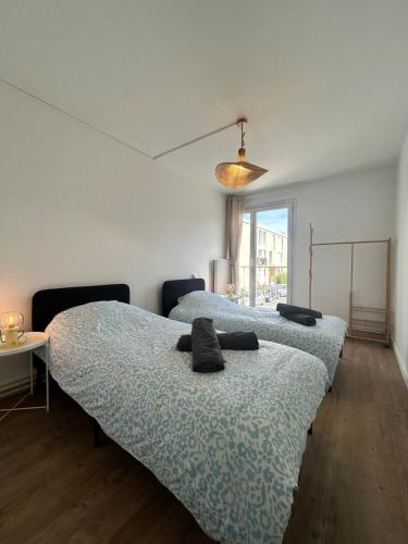 Cette chambre comprend deux lits. dans l'établissement Le Chambéry 6p parking privé clim, à Toulouse