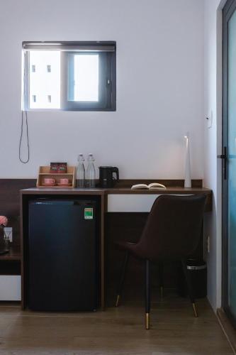 a desk with a chair in a room at Lynn by La Doma Express in Ho Chi Minh City