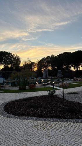 a park with umbrellas sitting on a brick walk way at Refúgio da Quinta Nere Maitia in Santarém
