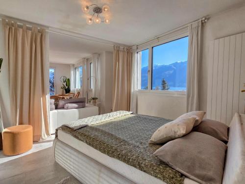a bedroom with a large bed with a large window at Lakeview Hideaway - Brissago in Brissago