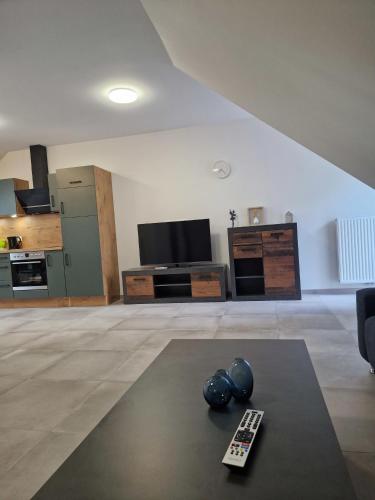 a living room with a television and a remote control at Wohnung 1 in Haselünne