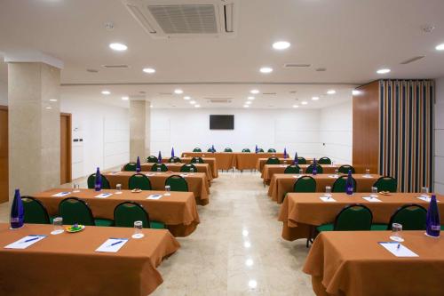 a large room with tables and chairs in it at NH San Pedro de Alcántara in Marbella