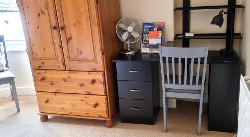 a desk and a chair next to a wooden dresser at 131 on Atholl in Pitlochry