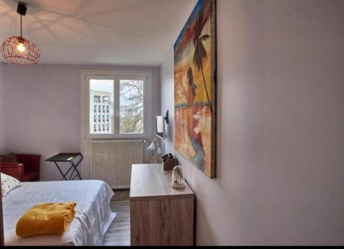 une chambre avec un lit et un tableau au mur dans l'établissement Chambres à louer dans appartement Balcon - wifi - parking gratuit, à Nevers