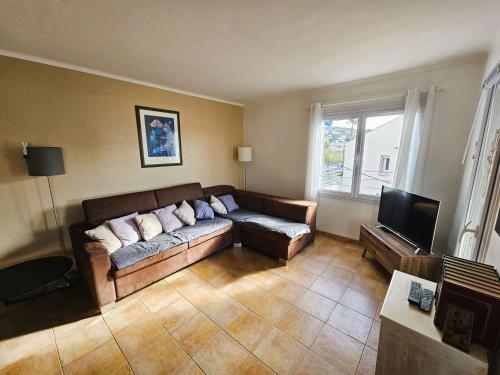 un salon avec un canapé et une télévision dans l'établissement Bel appartement avec balcon à 300m de plage, climatisation, internet..., à Six-Fours-les-Plages