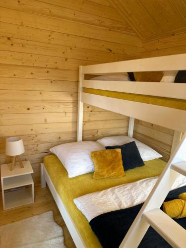 a bedroom with a bunk bed in a log cabin at Domek na Wiejskiej in Zator