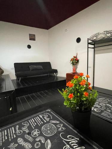 una camera con due letti e un vaso di fiori di Planet Suite Vesuvio a Ercolano