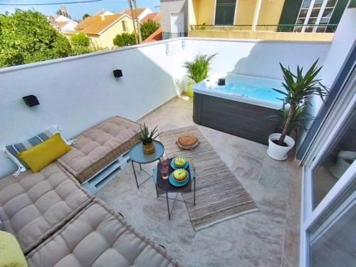 a balcony with a couch and a hot tub at Casa Lusitano by Valada Village in Valada