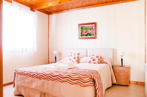 a bedroom with a bed and a painting on the wall at Complejo 21 de Enero - Luz y Fuerza in Puerto Madryn