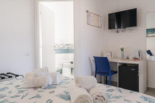 a room with a bed with towels on it at Caletta sul Mare in La Caletta