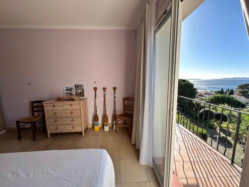 une chambre avec un lit et un balcon avec vue dans l'établissement Villa RoseAzur, au Lavandou
