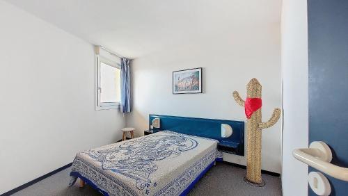 une petite chambre avec un lit et un cactus dans l'établissement V-Marin 02-Vieux Boucau Appartement 2 chambres avec vue sur le lac marin dans résidence avec piscine, à Vieux-Boucau-les-Bains