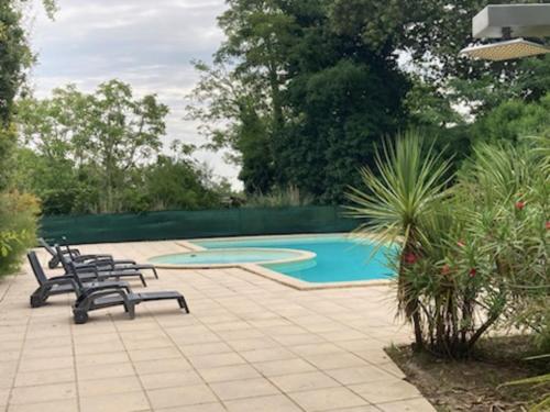 un patio avec deux chaises et une piscine dans l'établissement 3 pièces - Piscine - Proche plage, à Soulac-sur-Mer