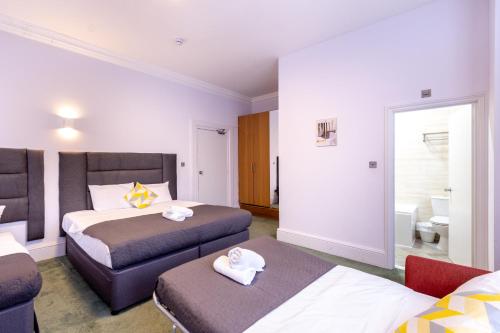 a hotel room with two beds and a bathroom at London Gatwick Inn in London