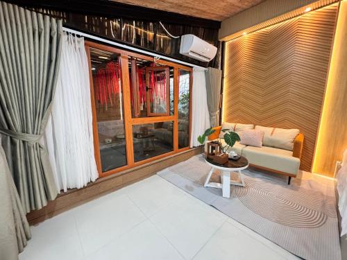 a living room with a couch and a table at Lá Garden Homestay in Long Xuyên