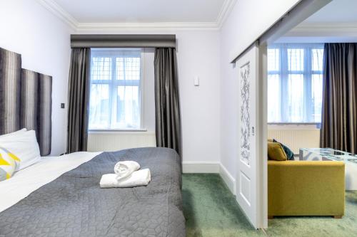 a bedroom with a bed and a couch and windows at London Gatwick Inn in London