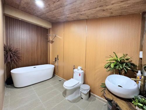 a bathroom with a tub and a toilet and a sink at Lá Garden Homestay in Long Xuyên