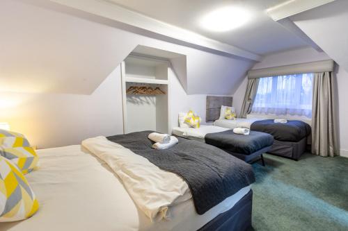 a bedroom with two beds and a couch and a window at London Gatwick Inn in London