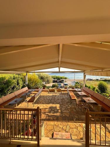 a group of tables and benches under an umbrella at Evita Luxury Apartments in Spilia
