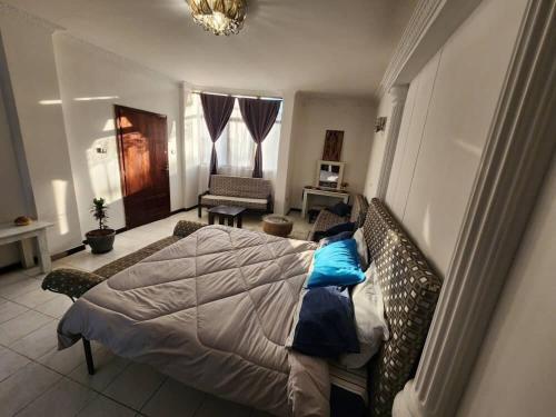 una camera da letto con un letto con cuscini blu di Seminat Spaces ad Addis Abeba