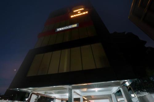 a tall building with a sign on it at night at Super Townhouse OAK The Dev Regency in Patna