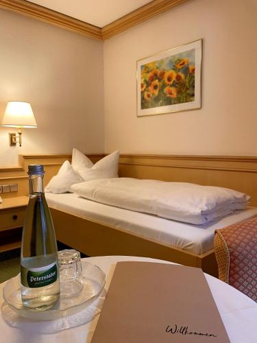 a hotel room with a bottle of wine on a table at Schwarzwaldhotel Klumpp in Baiersbronn