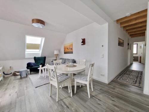 a white dining room with a table and chairs at Ferienwohnung LOUISE in Dreschvitz