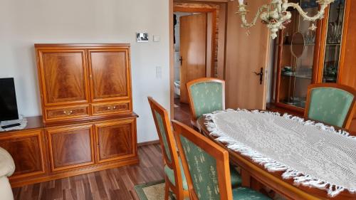 a dining room with a table and chairs and a cabinet at Pension Kapellenstraße - Ferienwohnung mit individueller Ausstattung - jedes Zimmer ist anders Komplette Küche in Erfurt
