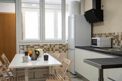 a kitchen with a white table and a microwave at Estudio Alojaguay in Valladolid