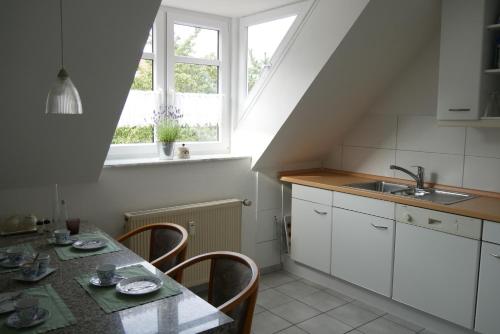 una cucina con tavolo, lavandino e finestra di Ferienwohnung Auszeit a Geeste
