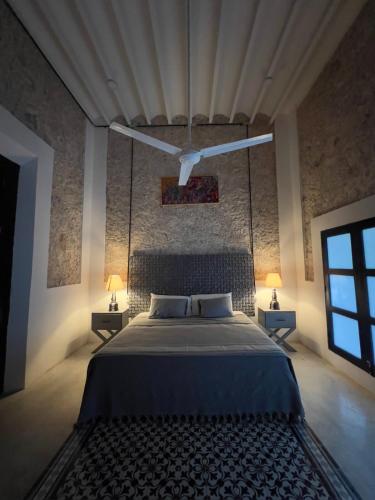a bedroom with a large bed with two lamps on two tables at Shakti Merida-facturamos in Mérida