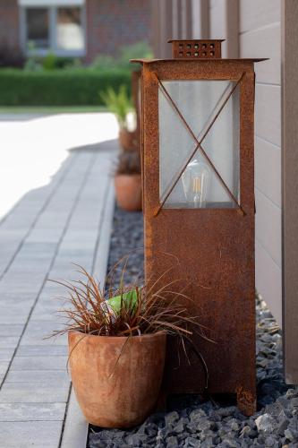 a wooden gate with potted plants on a walkway at Ferienwohnung Aurora in Winsen Luhe