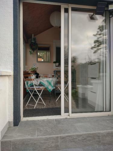 - une vue sur le patio par une porte coulissante en verre dans l'établissement Villa Les Palmiers, à Saint-Jean-de-Monts