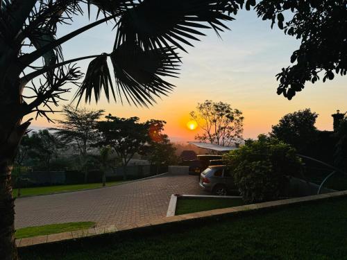 a car parked in a driveway with the sunset in the background at The Scenery Residence in Arusha